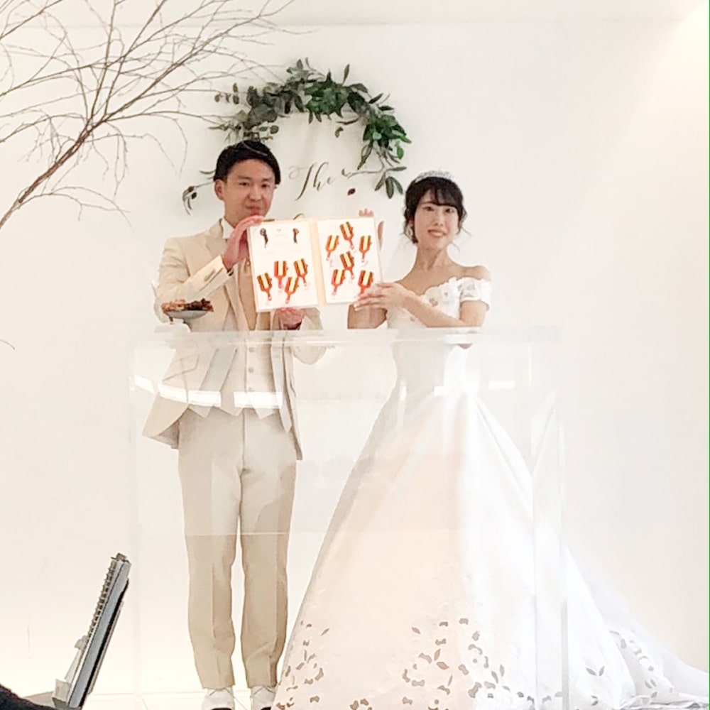 よさこい祭りをテーマにしたオリジナル結婚証明書をかかげる詩郎新婦