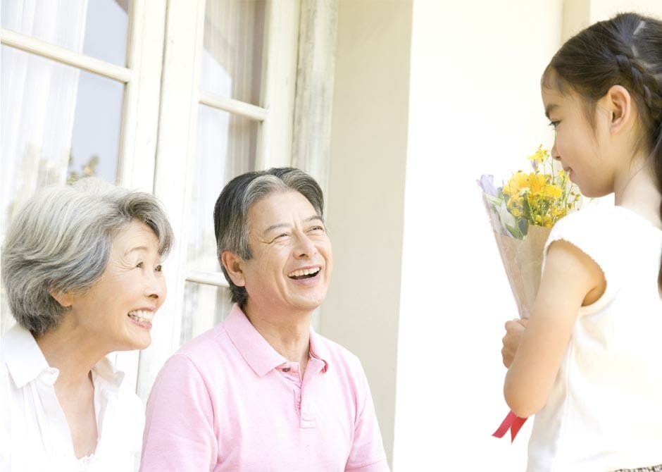 孫から祖父母へ敬老の日に花束を渡している