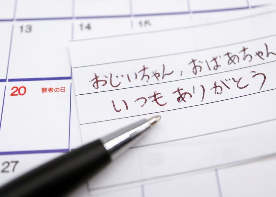 敬老の日に孫からおじいちゃんおばあちゃんへメッセージを書いている