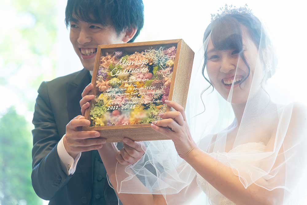 ファルベアンバサダー卒花レポ‗フラワー結婚証明書を掲げている新郎新婦