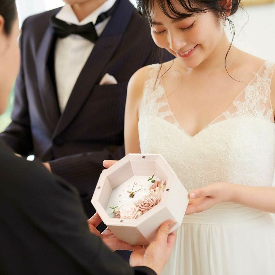 持ち運びに困らないサイズ感の八角花時計を渡す結婚式の贈呈シーン