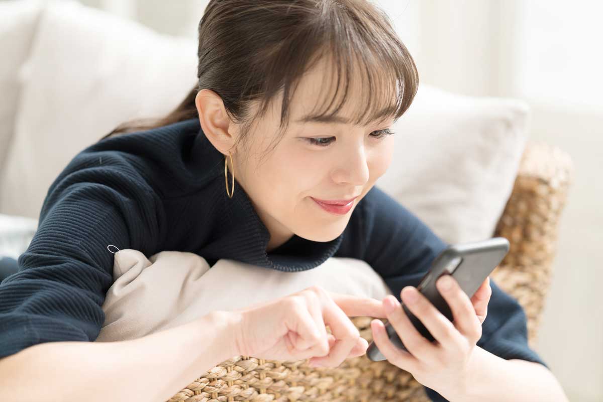 スマホを使って問い合わせてみる女性