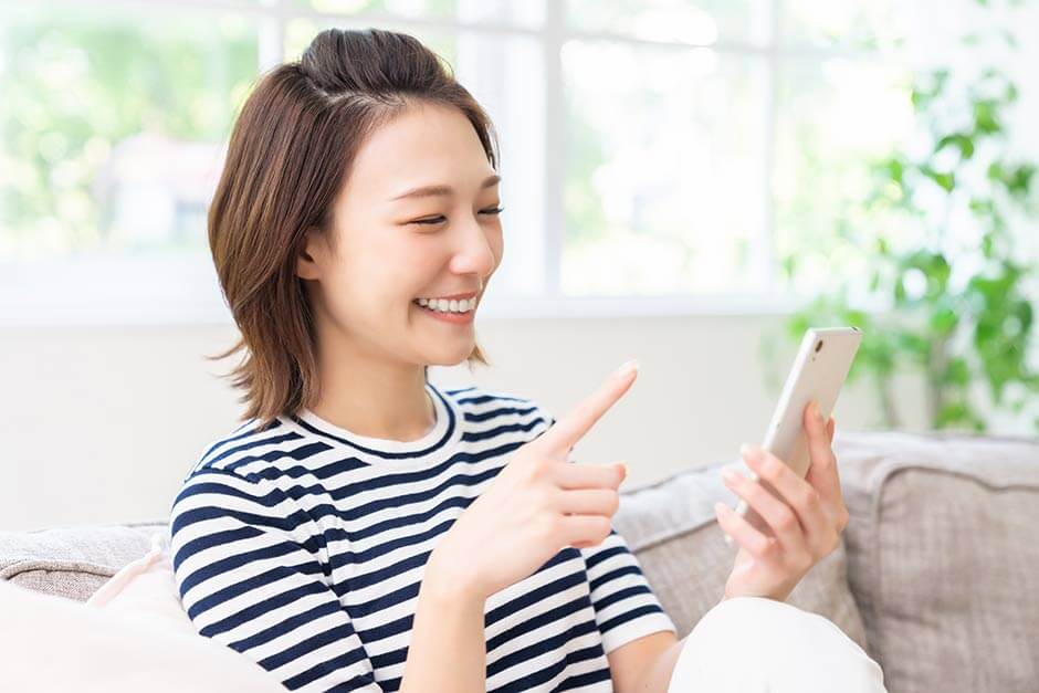 結婚式のWEB招待状をスマホで開いている新婦の友人