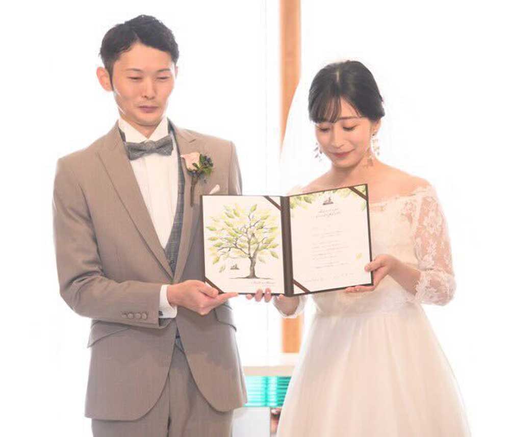 お客様の声_@akane.we.10.07様 結婚証明書を新郎新婦二人で手に持っているところ