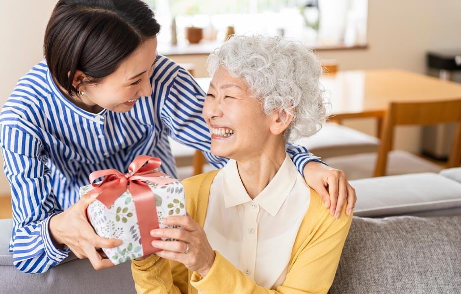 娘から還暦祝いのプレゼントをもらって喜んでいる母